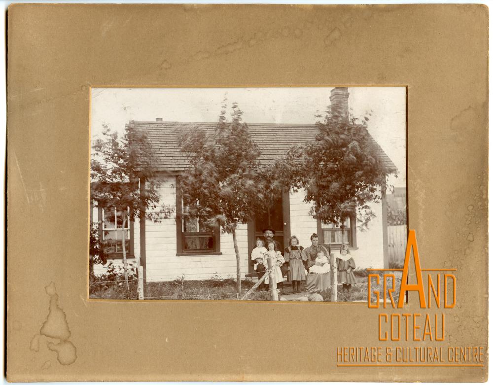 Photographic print, unidentified family in front of house