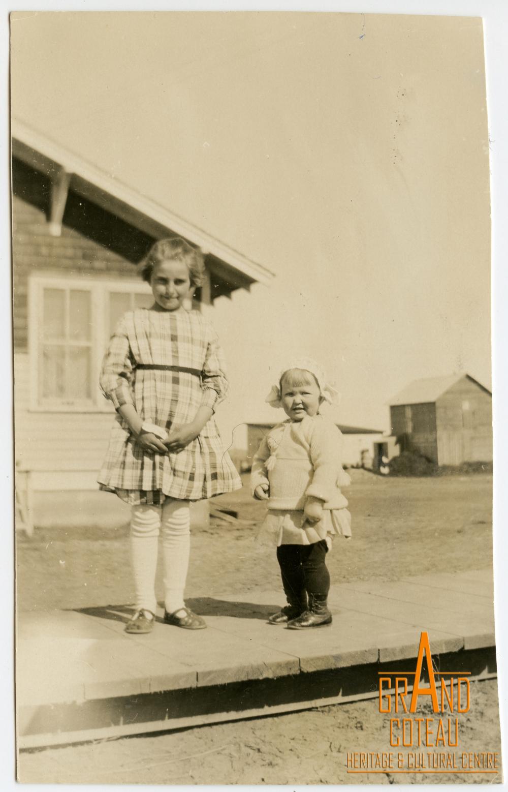 Photographic Print, 2 young children standing on a wooden sidewalk