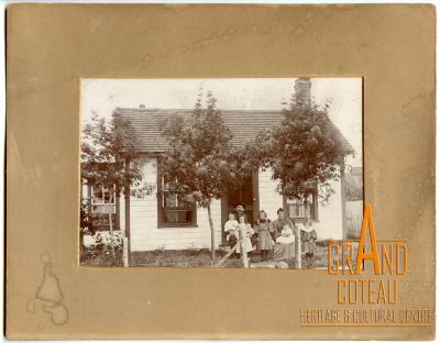 Photographic print, unidentified family in front of house