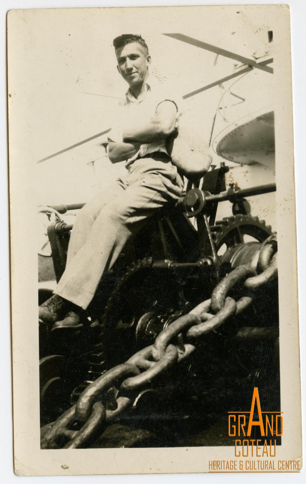 Photographic Print, unidentified man sitting on anchor hoist of a ship.