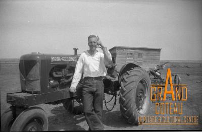 Photographic negative, Len Hymie Hanft beside his new Allis-Chalmers tractor, 1940