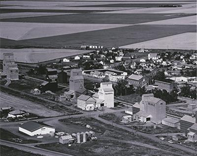 SK: Milestone - A grain elevator community as it appears at harvest time.