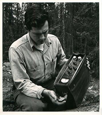 SK: Beaverlodge - Geologist Jack Silman with Geiger counter working a claim for Nesbitt-Labine uranium mines