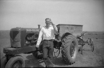 Photographic negative, Len Hymie Hanft beside his new Allis-Chalmers tractor, 1940