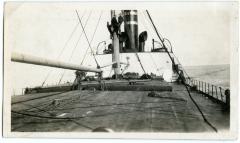 Photographic Print, Deck of a ship with three unidentified men in the rigging.