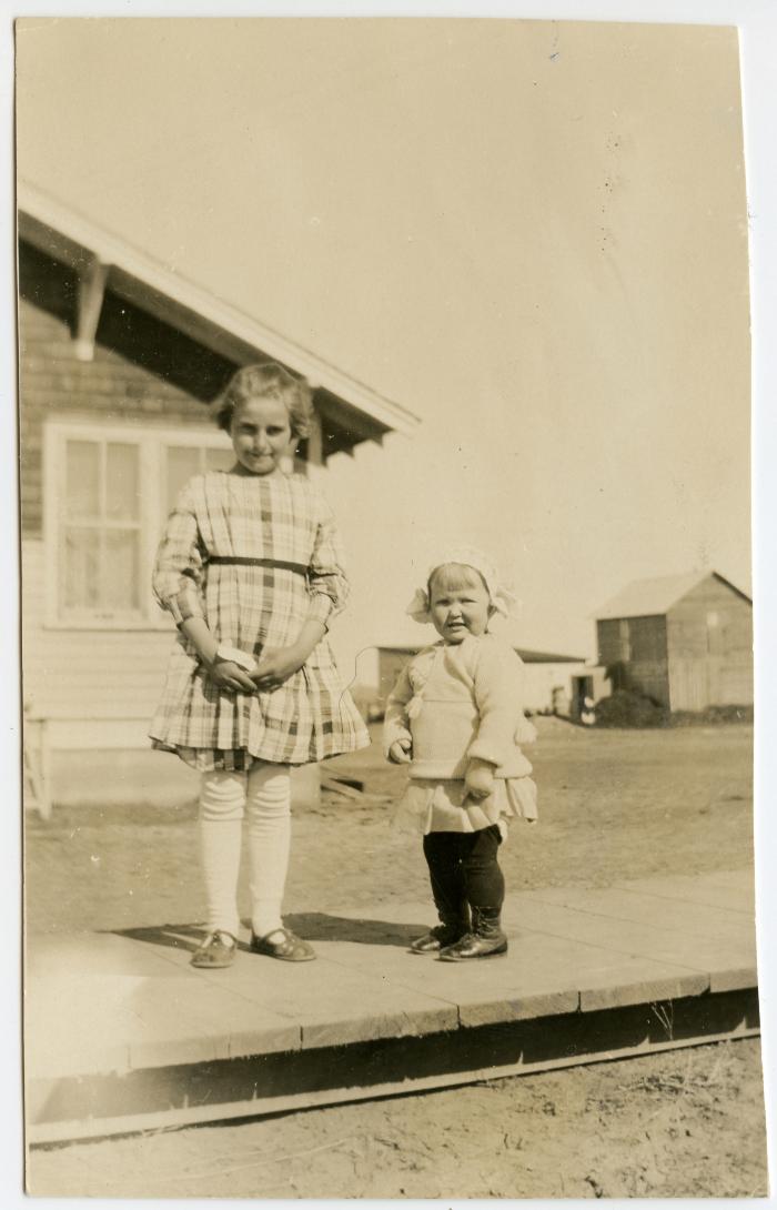 Photographic Print, 2 young children standing on a wooden sidewalk