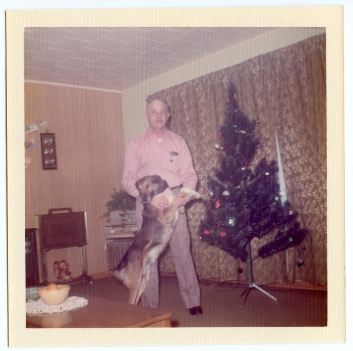 Photographic print, Joe Richtik with dog in his living room at Christmas