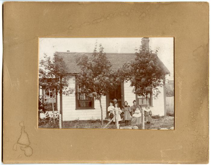 Photographic print, unidentified family in front of house