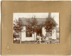 Photographic print, unidentified family in front of house