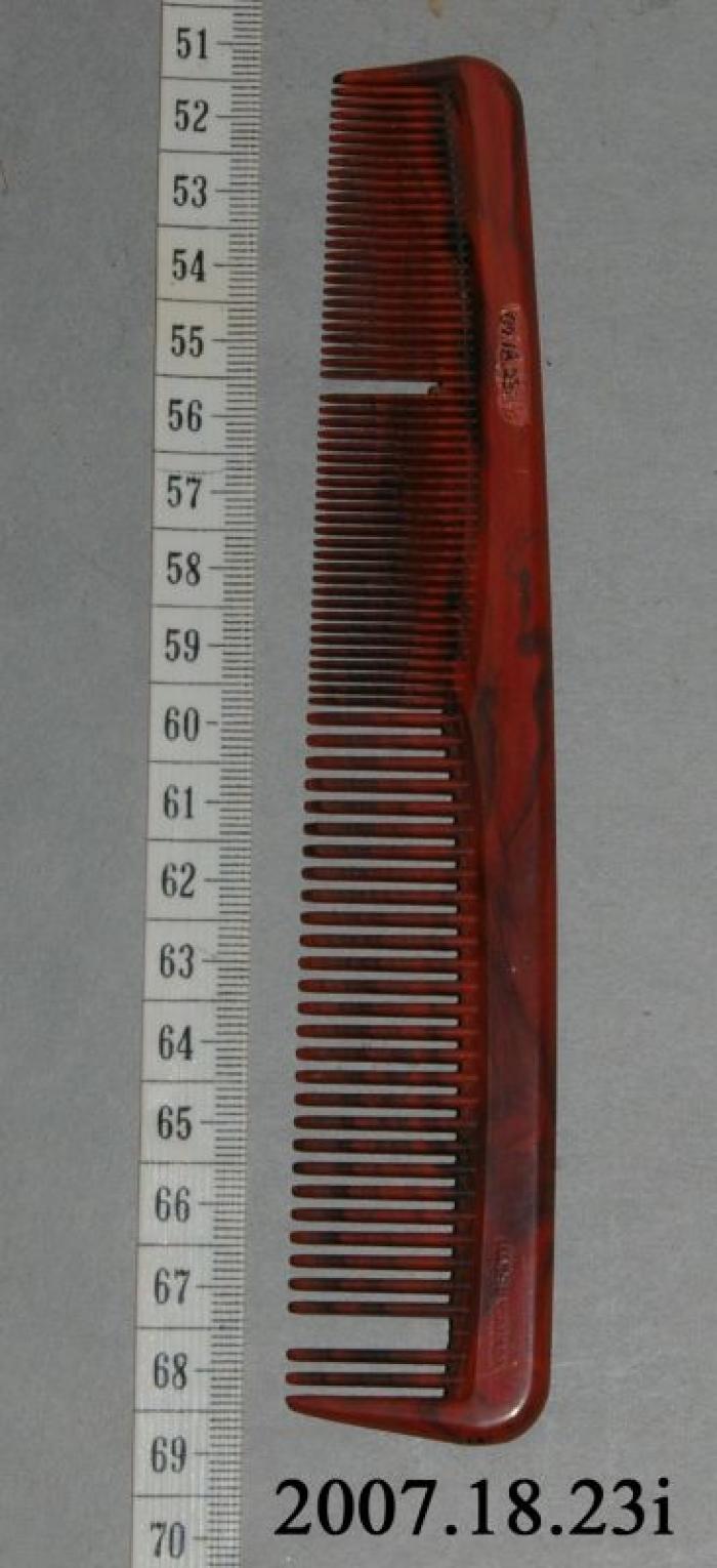 Hair Comb;Hair Comb;Marbled black and terra-cotta coloured comb, fine teeth at one end, broader at the other. Found with hair clipper set, but did not originally come with it.;Plastic Comb