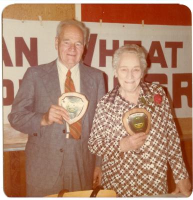 Colour photo of Ruth and Everett Baker with plaques presented from Saskatchewan Wheat Pool