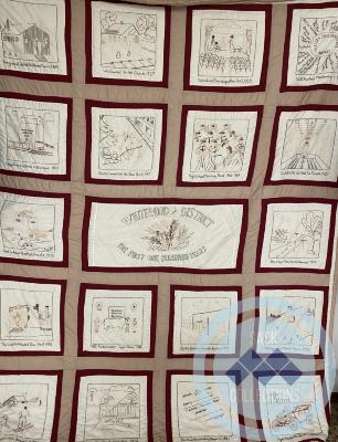 Quilt - commemorative quilt made for Whitewood Centennial by Joyce Kydd. Brown cream and maroon polycotton with beige and brown embroidery. 1982. Won by Fred Johnston in Quilt Raffle in 1982