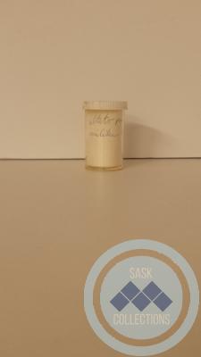 Clear, cylinder, pill capsule with a white lid with yellow pills inside. 
